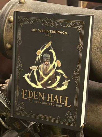 Eden Hall – Die Aufnahmeprüfung“, Band 1 der Wellvern-Saga, mit goldverzierten Illustrationen und steampunk-inspiriertem Design.